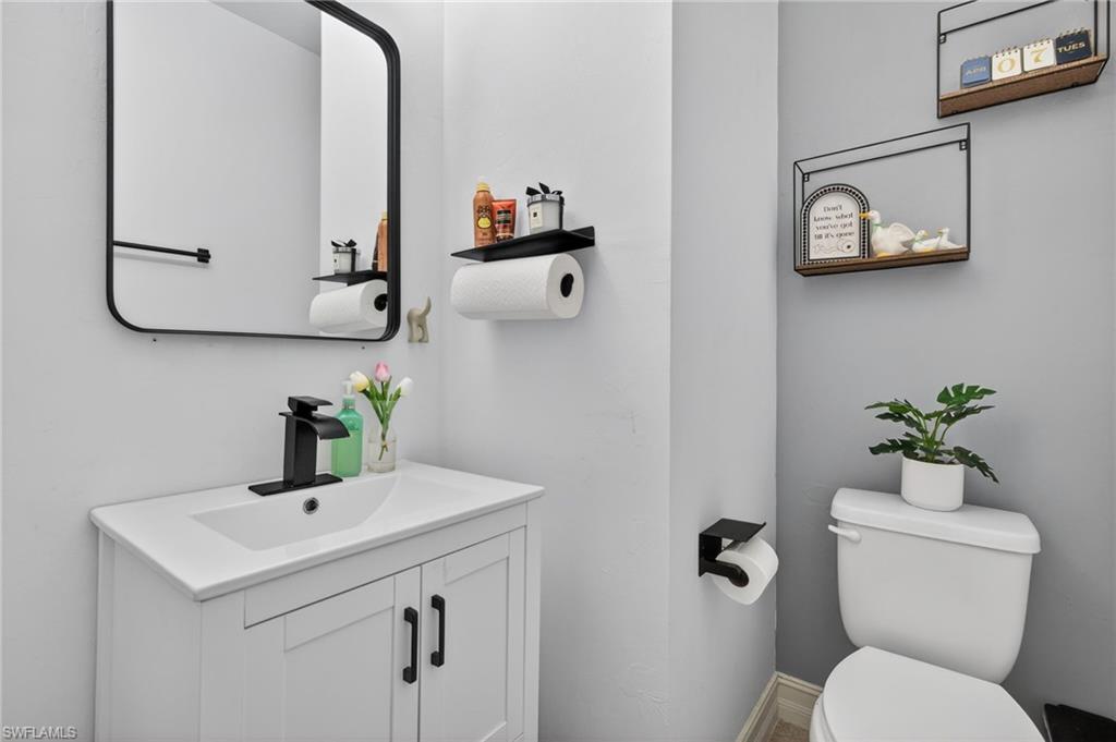 7845 Bristol Circle Naples, FL 34120 - Photo 24 of 31 a bathroom with a toilet sink and mirror