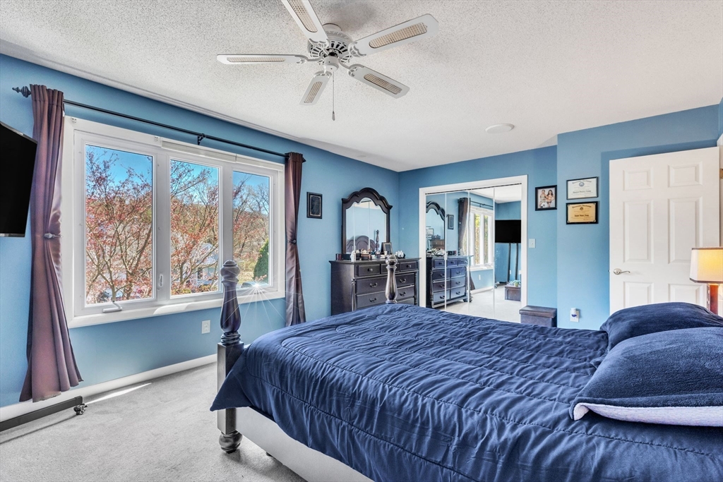 610 County Road, Unit 2 Holyoke, MA 01040 - Photo 19 of 42 a spacious bedroom with a large bed and a chandelier
