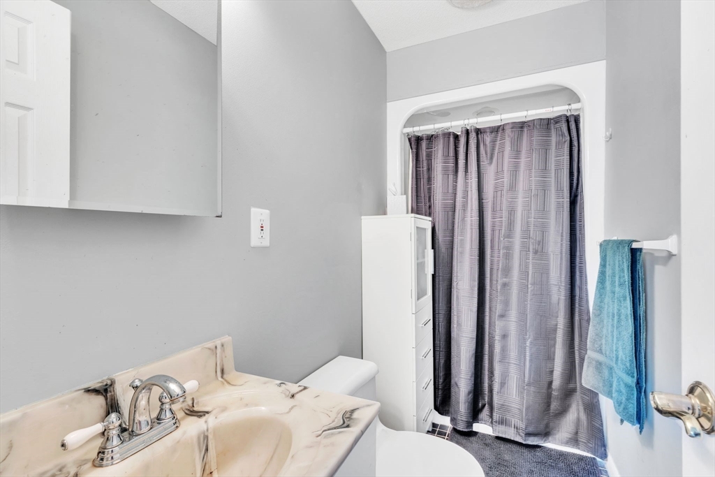 610 County Road, Unit 2 Holyoke, MA 01040 - Photo 22 of 42 a bathroom with a sink a toilet and shower curtain