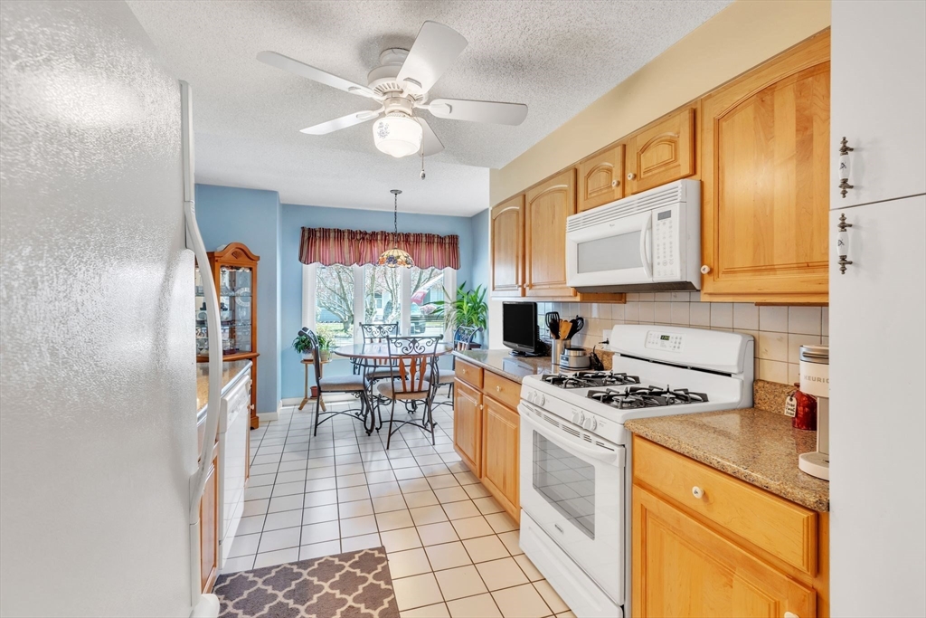 610 County Road, Unit 2 Holyoke, MA 01040 - Photo 7 of 42 a kitchen with a stove a sink a dining table and chairs