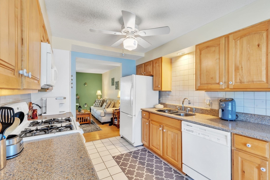 610 County Road, Unit 2 Holyoke, MA 01040 - Photo 10 of 42 a kitchen with a stove a sink dishwasher and a refrigerator with wooden floor