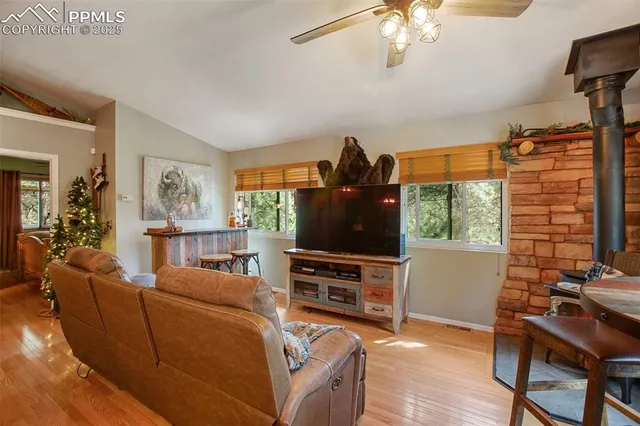 a living room with furniture a dining table and a flat screen tv with wooden floor