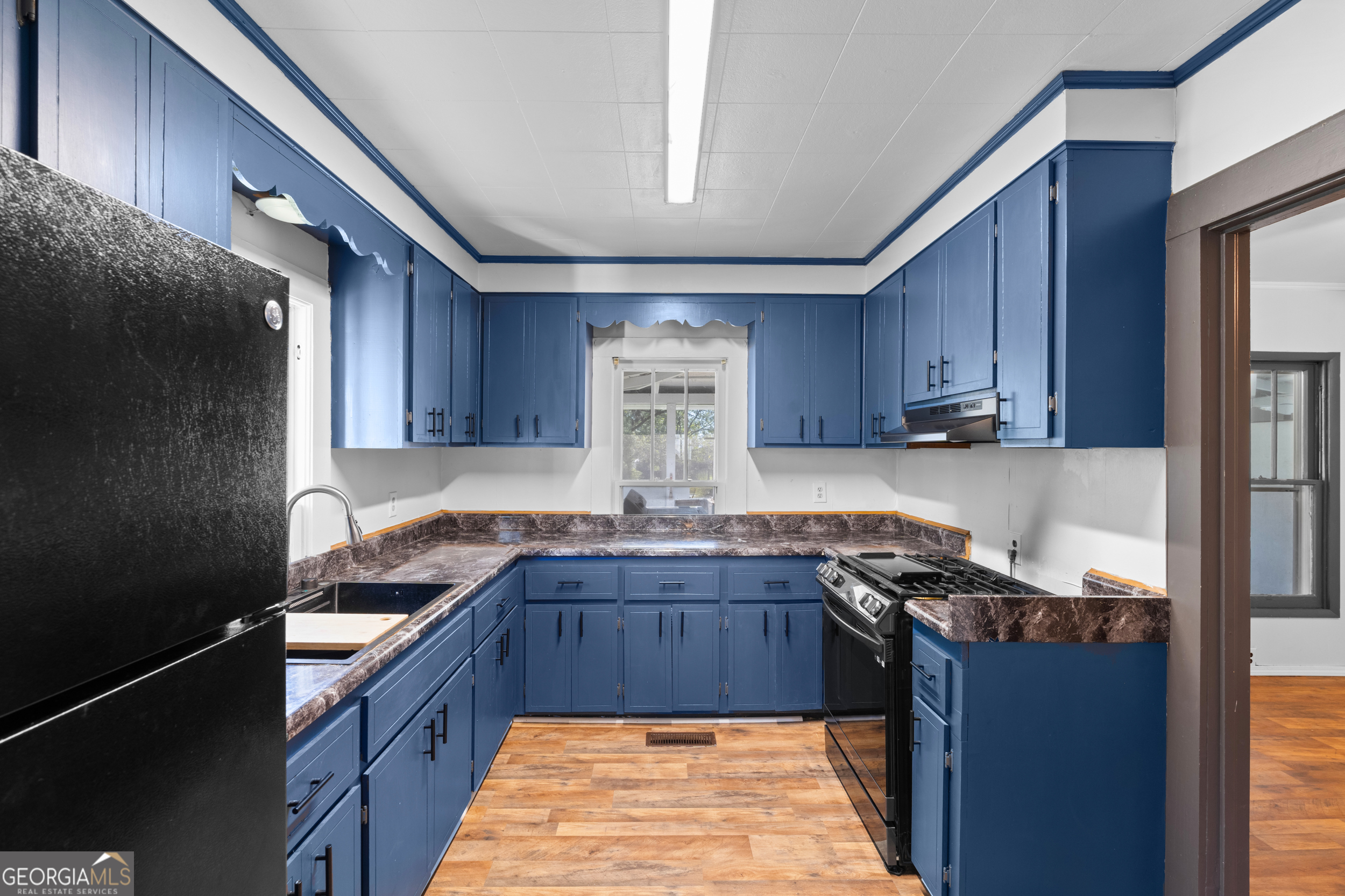 2 Finch Street Portal, GA 30450 - Photo 6 of 23 a kitchen with granite countertop a sink stove and cabinets