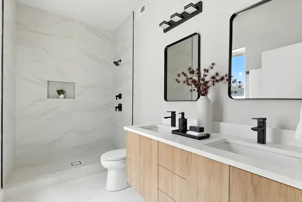 a bathroom with a sink a toilet and shower