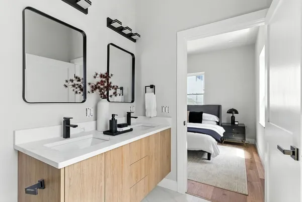 a bathroom with double vanity sinks and a mirror