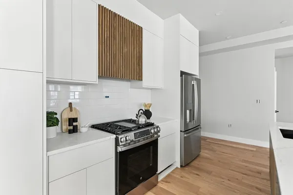 a kitchen with stainless steel appliances granite countertop a refrigerator stove and sink