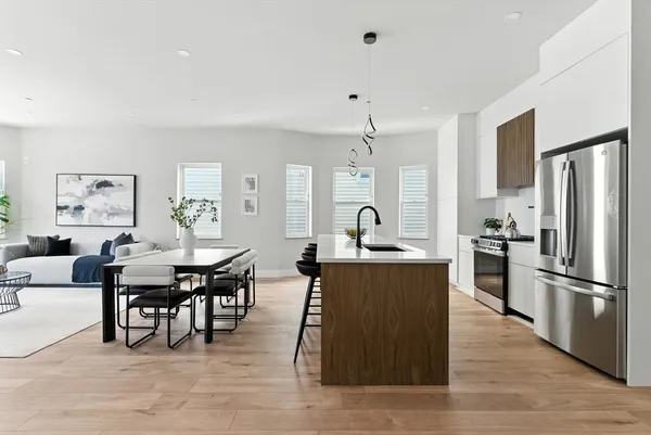 a large kitchen with cabinets table and chairs