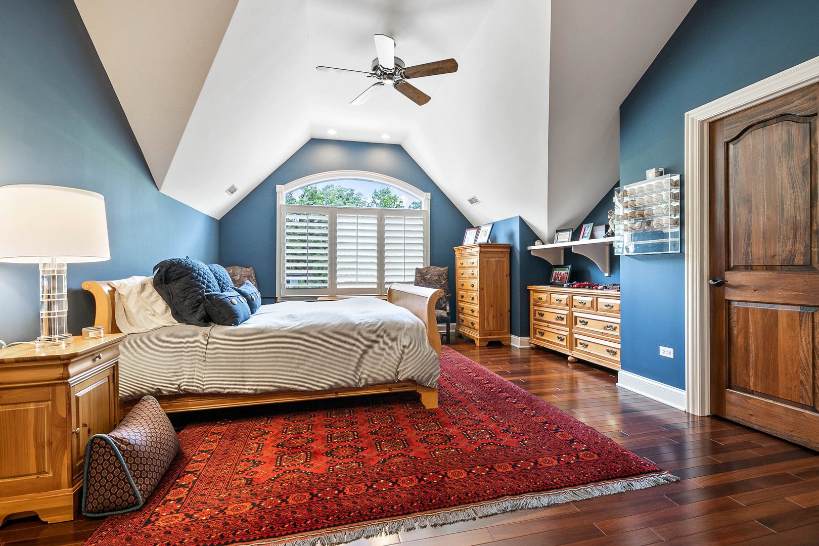 992 Sylvan Circle Naperville, IL 60540 - Photo 22 of 36 a spacious bedroom with a bed a chandelier and a window