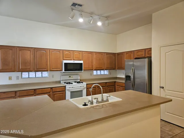 a kitchen with kitchen island a sink appliances and cabinets