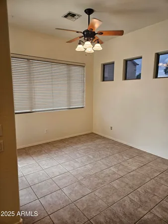 a view of a livingroom with a chandelier fan and windows