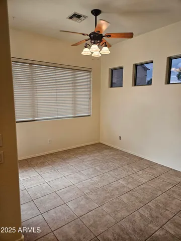 a view of a livingroom with a chandelier fan and windows