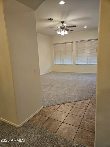 a view of an empty room with a chandelier fan