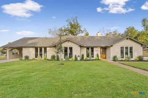 a front view of a house with a yard and trees