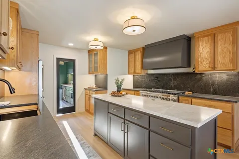 a kitchen with a sink appliances and cabinets