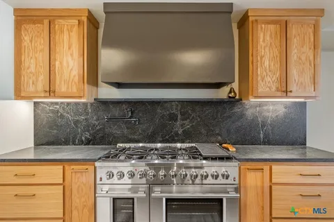 a stove top oven sitting inside of a kitchen