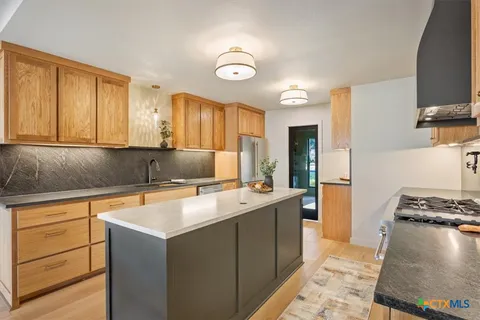 a kitchen with a sink stove and cabinets