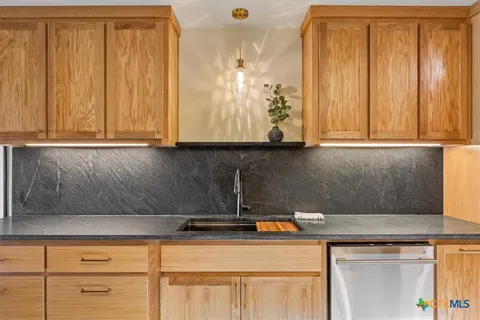 a kitchen with cabinets appliances and a window