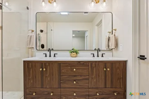 a bathroom with a sink double vanity and a shower