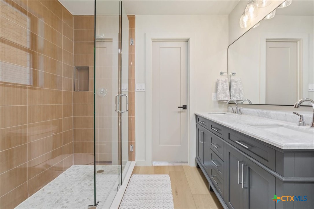 4306 Spanish Oak Road Temple, TX 76502 - Photo 24 of 36 a bathroom with a granite countertop sink a mirror and a shower