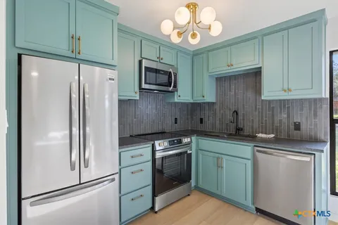 a kitchen with stainless steel appliances granite countertop a sink a stove and cabinets