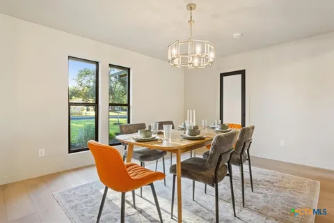 a view of a dining room with furniture a chandelier and wooden floor
