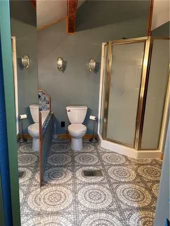 a bathroom with a toilet and a shower