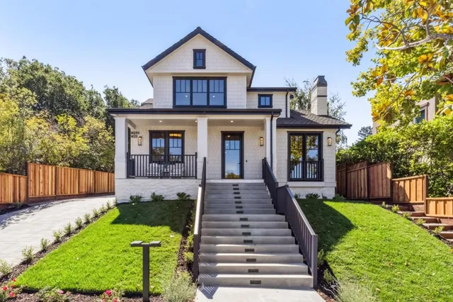 a front view of a house with yard and green space