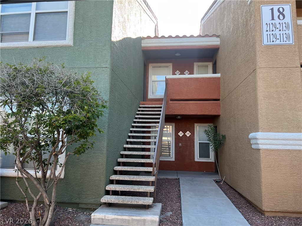 8101 West Flamingo Road, Unit 2129 Las Vegas, NV 89147 - Photo 12 of 12 A welcoming entryway with a concrete walkway leads to an outdoor staircase, connecting multiple levels of residential units.
