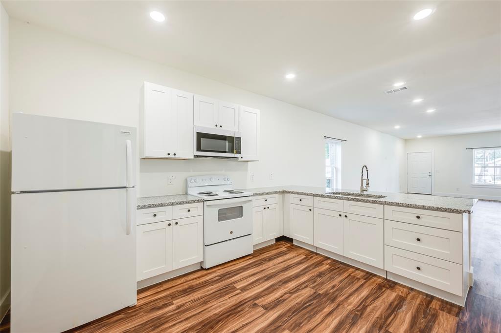 3525 Herrling Street Dallas, TX 75210 - Photo 17 of 28 a kitchen with white cabinets and white appliances