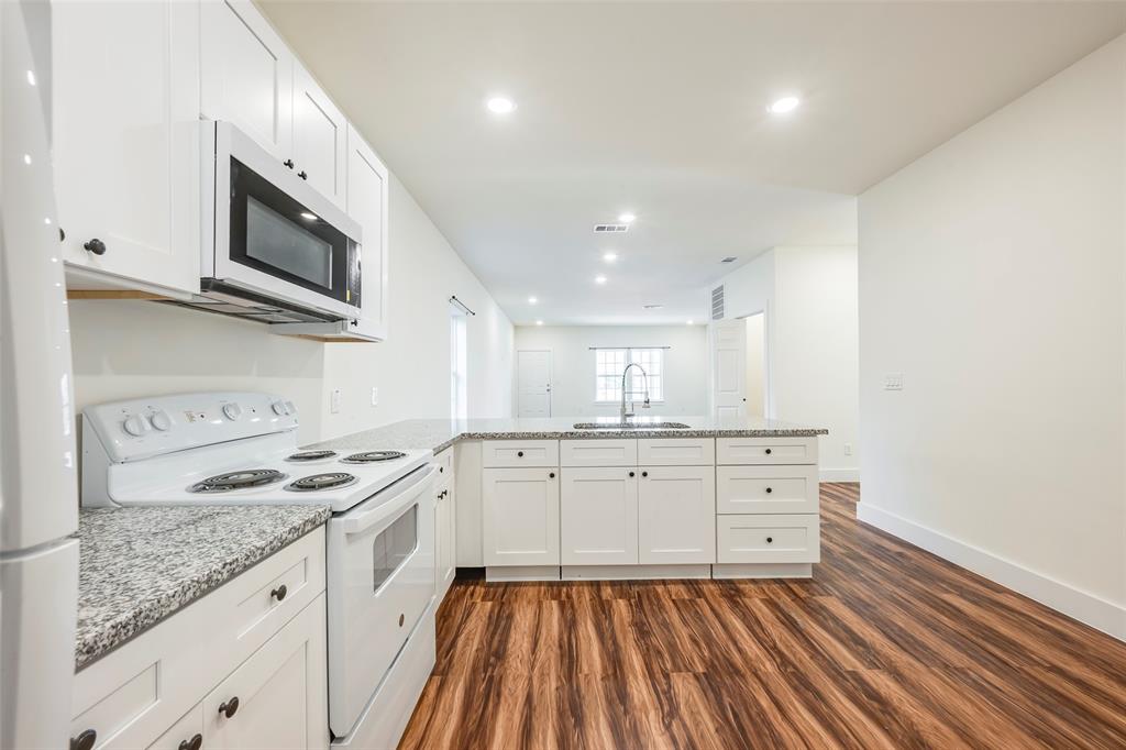 3525 Herrling Street Dallas, TX 75210 - Photo 18 of 28 a kitchen with stainless steel appliances granite countertop a stove a sink and a microwave