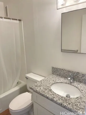 a bathroom with a granite countertop sink toilet and shower