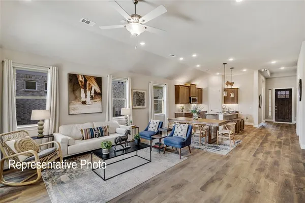 a living room with furniture kitchen view and a chandelier