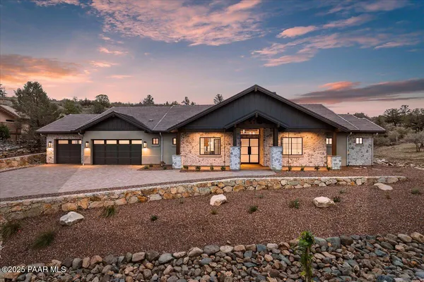 a view of a house with a yard and large tree