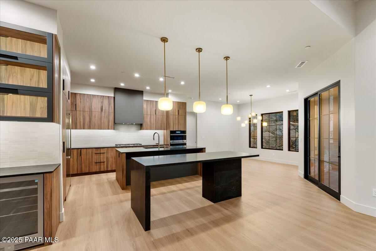 125 Rotonda Way Prescott, AZ 86301 - Photo 13 of 38 a kitchen with stainless steel appliances kitchen island granite countertop a refrigerator a stove and a wooden floors