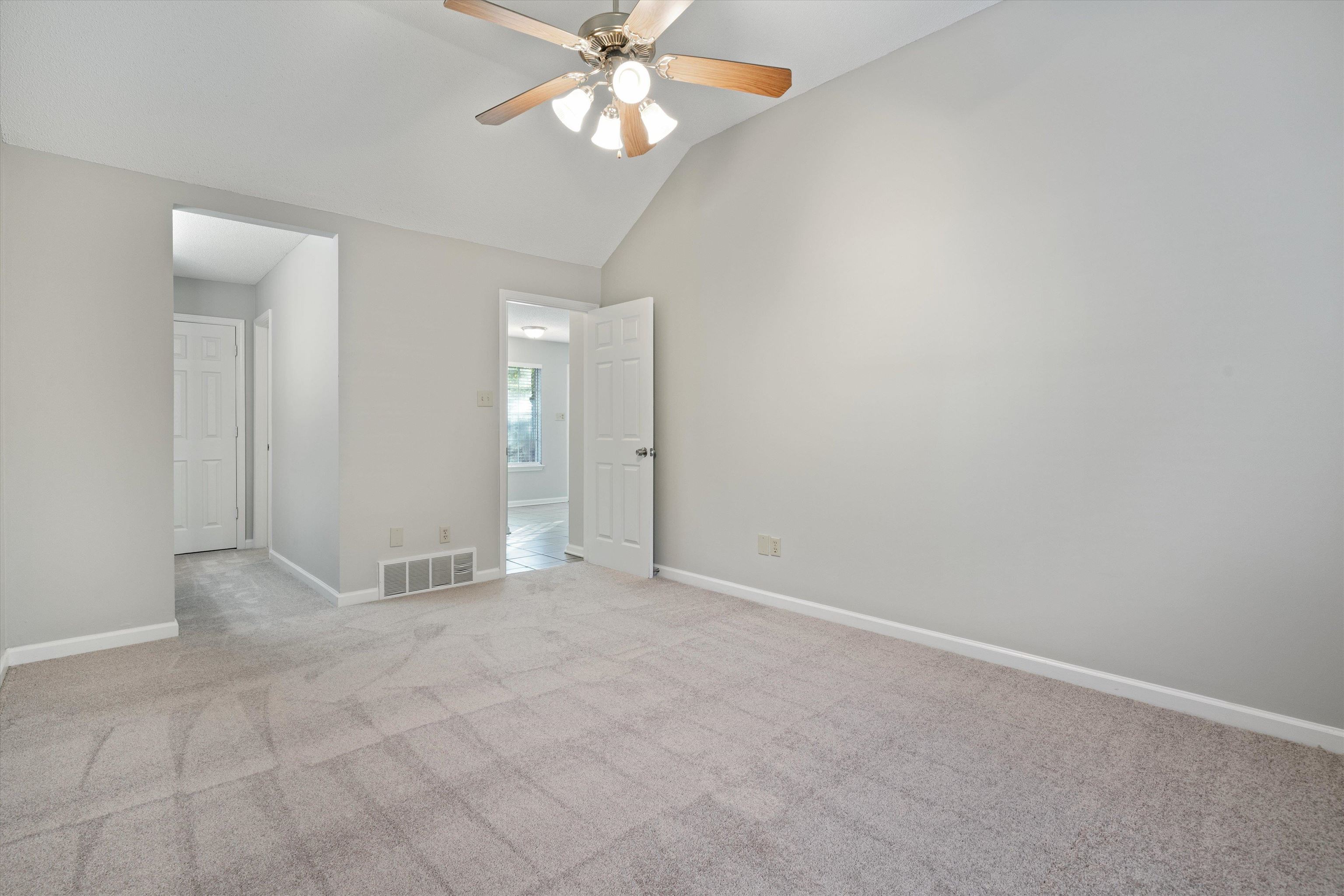 6511 Patmore Road Memphis, TN 38134 - Photo 12 of 22 an empty room with a chandelier fan and windows