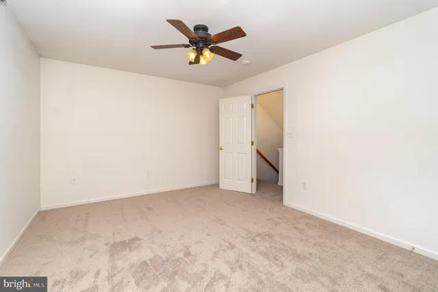 an empty room with a ceiling fan and window