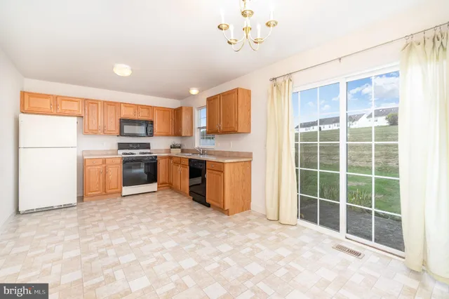 a kitchen with a refrigerator a stove top oven and a sink