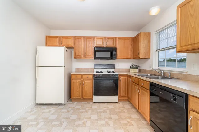 a kitchen with stainless steel appliances granite countertop a refrigerator sink and stove