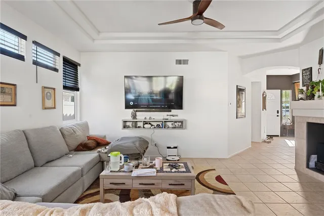 a living room with furniture a flat screen tv and a chandelier