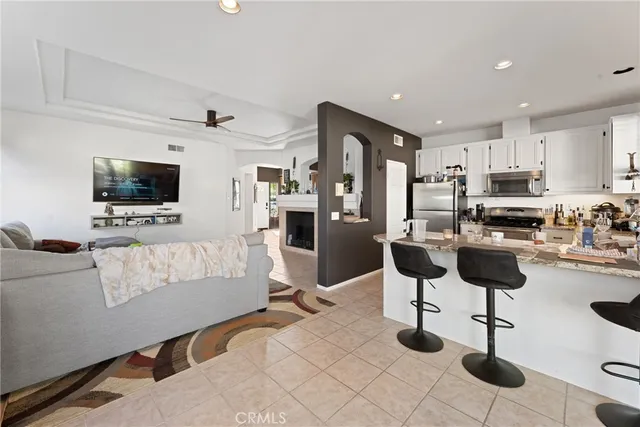 a living room with stainless steel appliances furniture and a flat screen tv