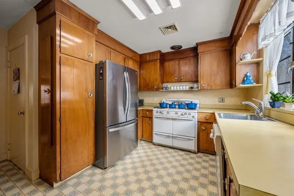 a kitchen with stainless steel appliances granite countertop a refrigerator a stove and a sink