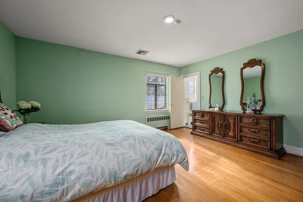 a spacious bedroom with a bed and a dresser
