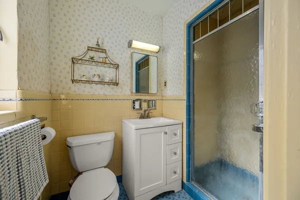 a bathroom with a toilet a sink and mirror