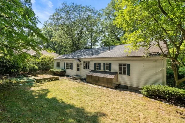 a view of a yard in front of a house with large trees