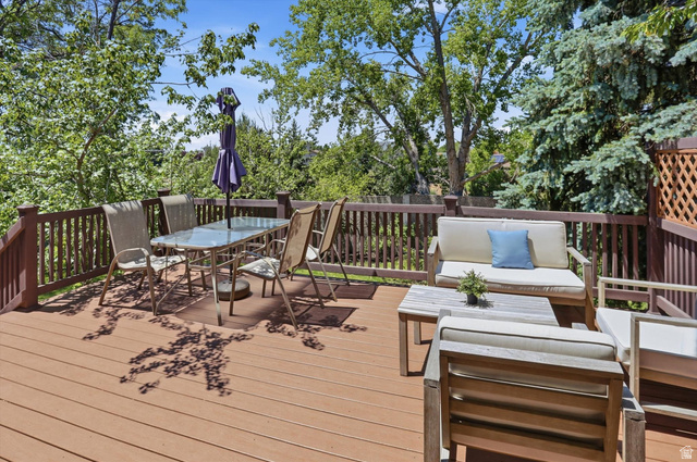 8938 Manchester Lane Sandy, UT 84093 - Photo 34 of 50 Spacious outdoor deck featuring composite wood-finish flooring, dark wood railings, and an integrated lattice privacy screen