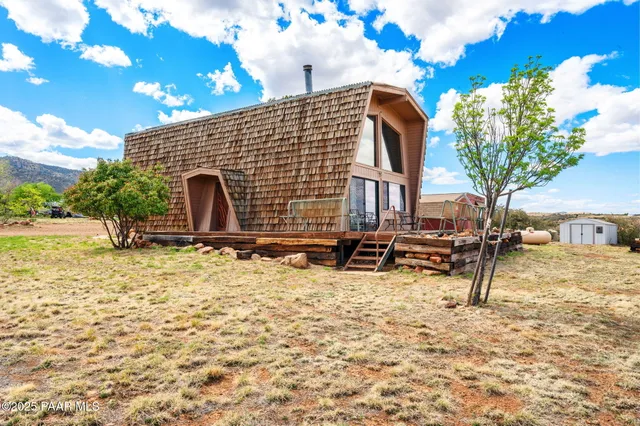 a backyard of a house with table and chairs