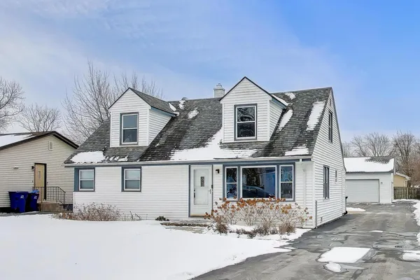 a front view of a house with a tree