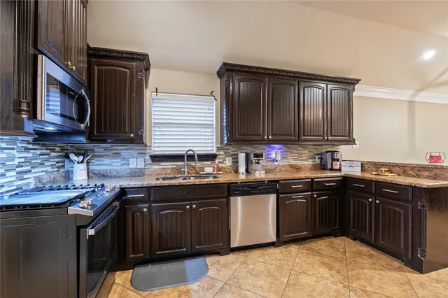 a kitchen with stainless steel appliances granite countertop a sink stove and cabinets