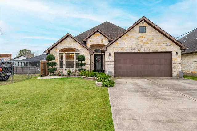 a front view of a house with a garden and yard
