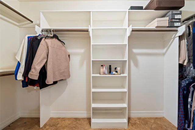 a view of walk in closet with clothes and shoes
